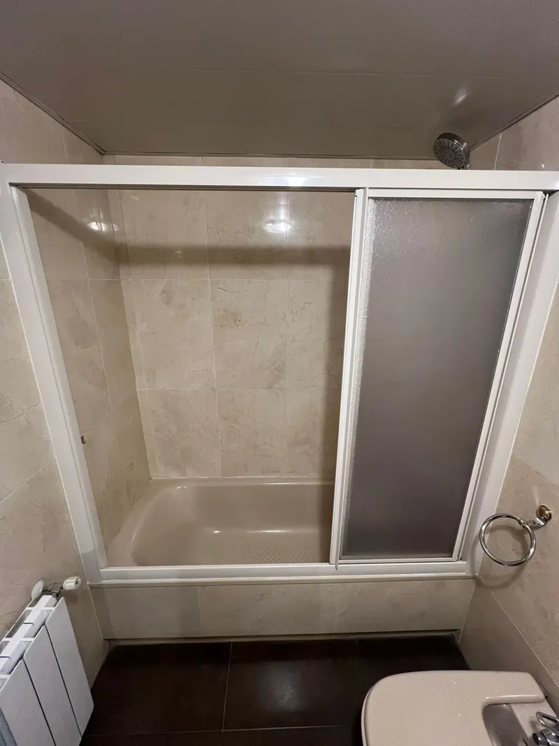 Baño antes de la reforma: bañera con mampara corredera